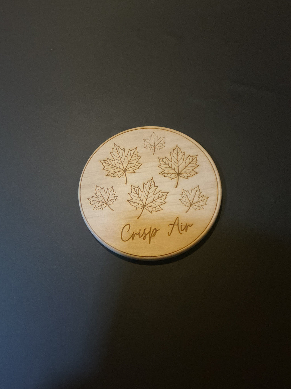 Crisp Air laser engraved wood coaster with scattered maple leaves