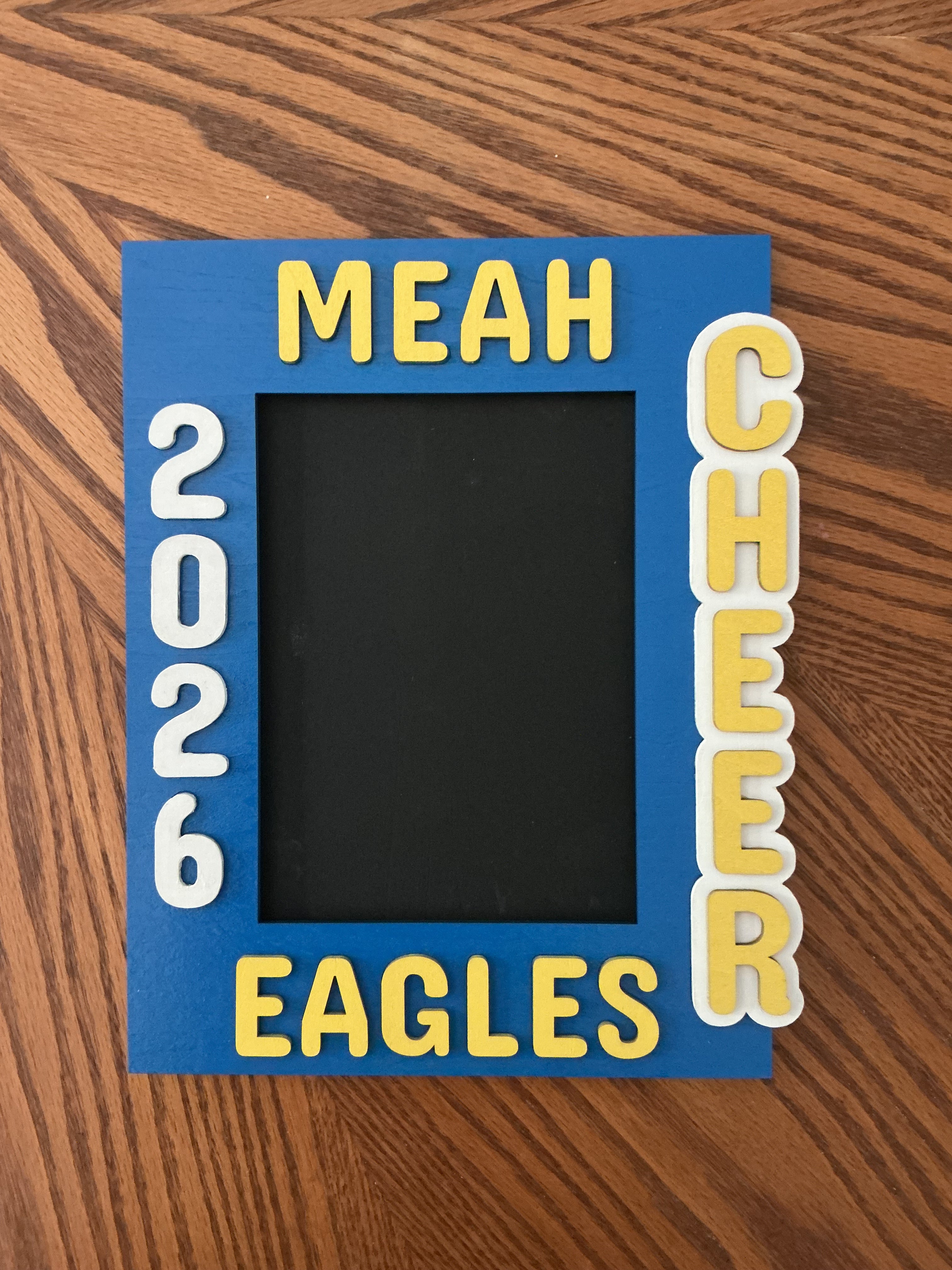 Blue cheer frame with CHEER lettering → "Blue and yellow painted wood laser engraved cheer picture frame with vertical lettering"