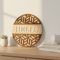 Hello circular laser engraved wood sign leaning against white wall with neutral home decor